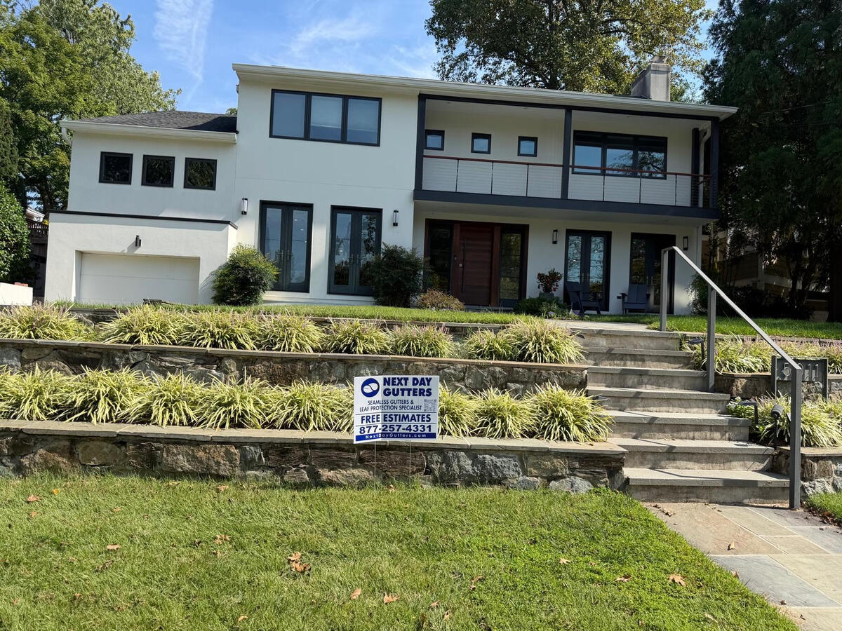 Custom Eggshell 6-inch seamless aluminum K-style gutters and matching downspouts on a contemporary Bethesda, MD home.
